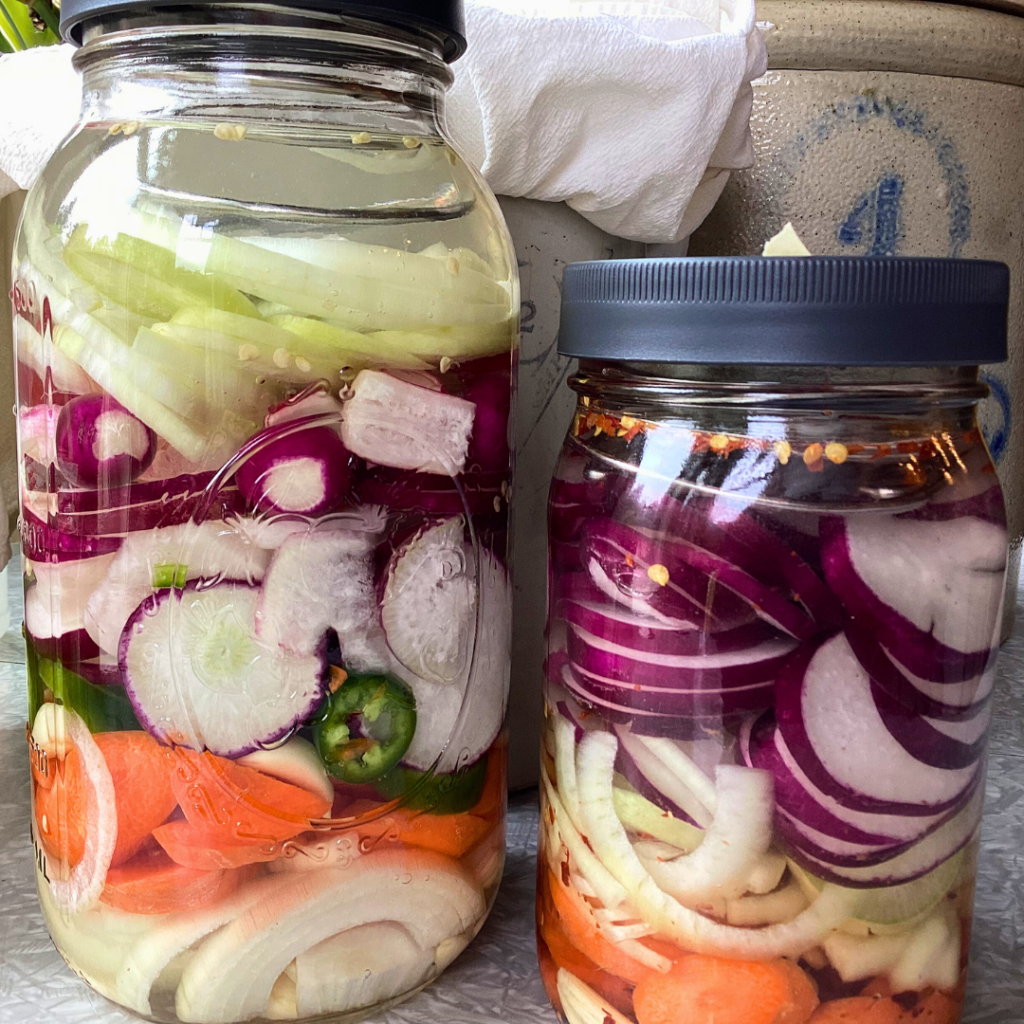Two jars of onions, radish, jalapeño, carrot and garlic fermenting.
