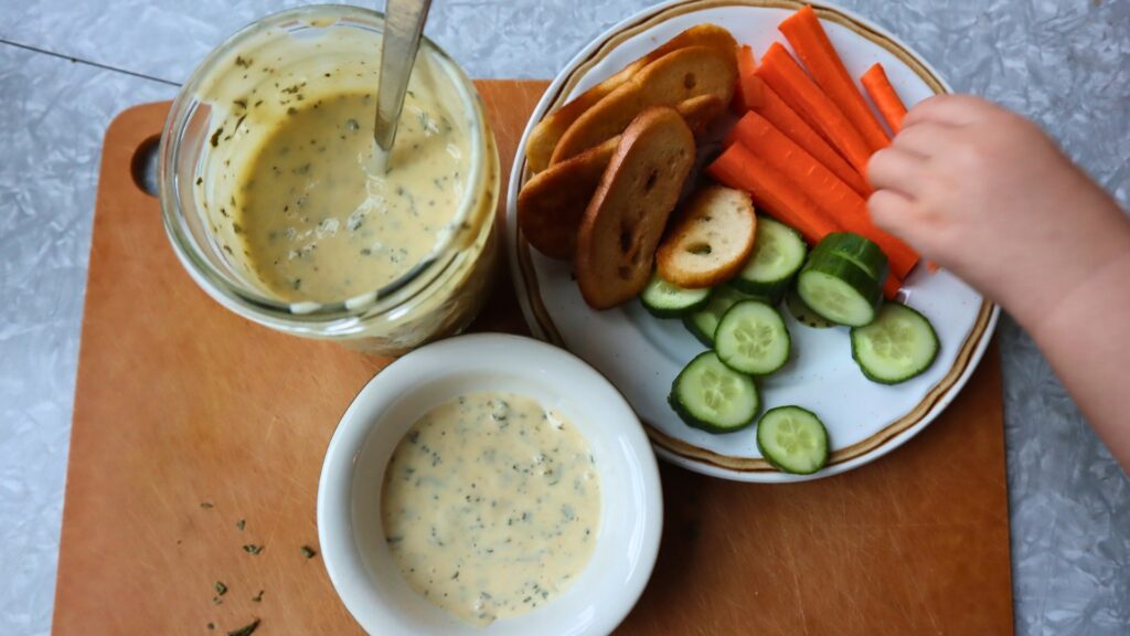 Homemade kefir ranch with plate of veggies and crackers for dipping.
