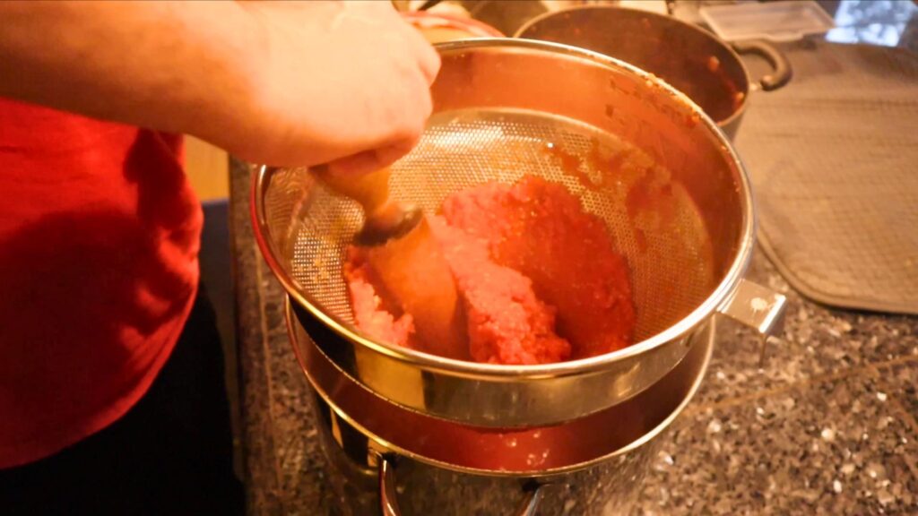Straining seeds from tomato sauce.